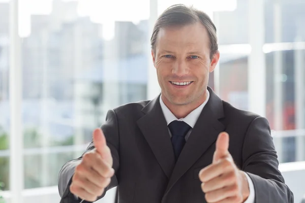 Empresário sorridente dando os polegares para cima — Fotografia de Stock