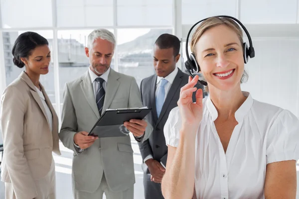 Smiling woman standing with a headset — Stock Photo, Image