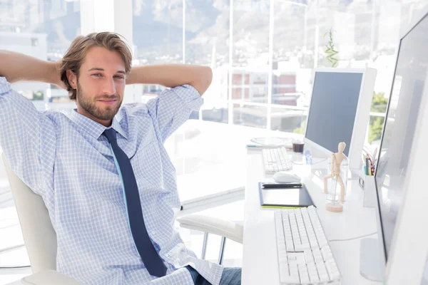 Diseñador sonriente con brazos detrás de la cabeza — Foto de Stock