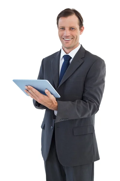 Empresário sorridente segurando um computador tablet — Fotografia de Stock