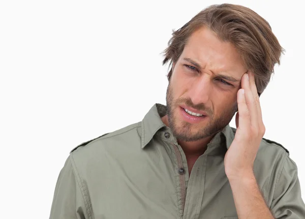 Hombre con dolor de cabeza mirando hacia otro lado y haciendo una mueca — Foto de Stock