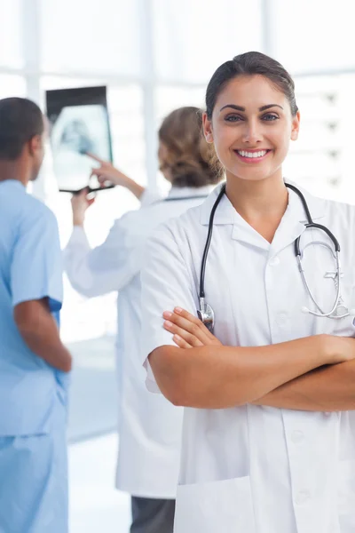 Mujer joven doctora con los brazos cruzados mirando a la cámara — Foto de Stock