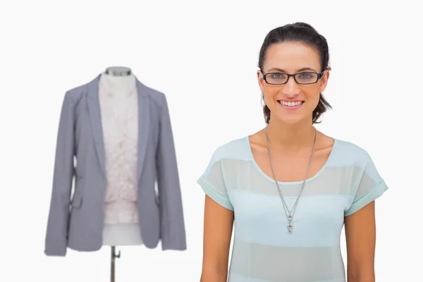 Designer smiling at camera with mannequin behind — Stock Photo, Image