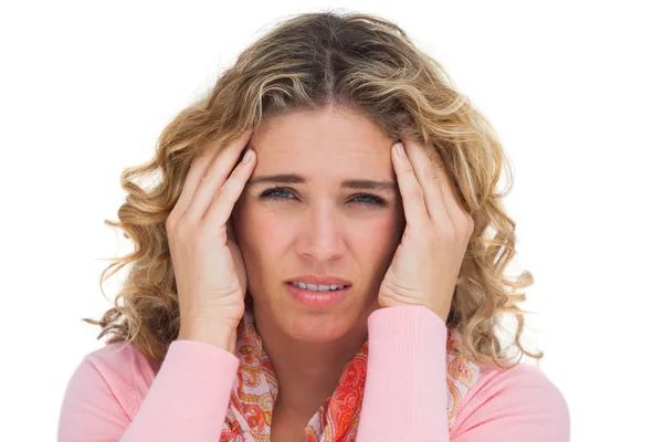 Blonde woman suffering with headache thus touching her temples — Stock Photo, Image