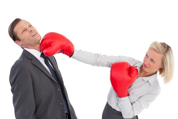 Businesswoman hitting colleague with her boxing gloves — Stock Photo, Image