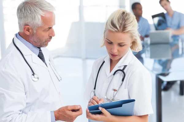 Two doctors holding a blue file — Stock Photo, Image