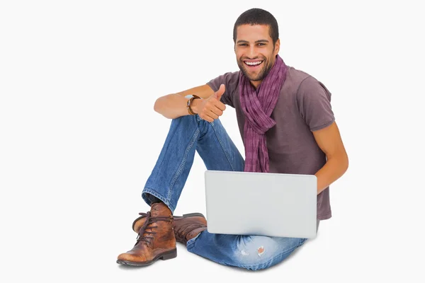 Happy man sitting on floor using laptop giving thumbs up — Stock Photo, Image