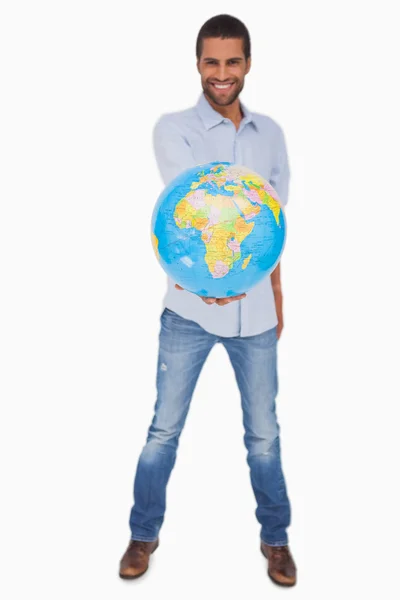 Happy man holding out a globe — Stock Photo, Image