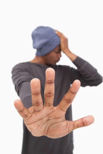 Adam durdurmak için elini uzatarak bere şapka — Stok fotoğraf