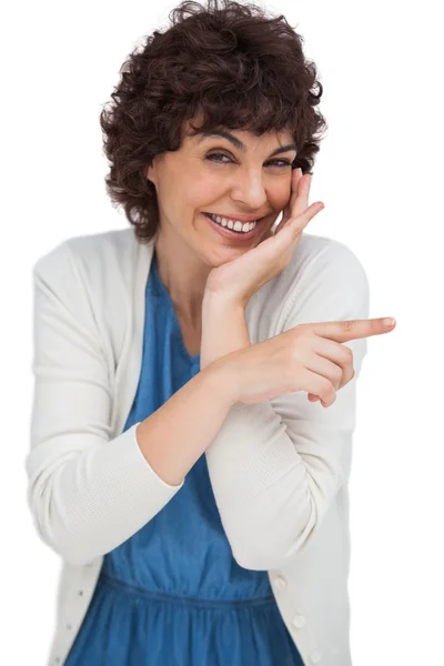 Mujer sonriente señalando algo con su dedo — Foto de Stock