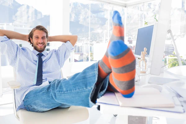 Designer entspannt sich ohne Schuhe am Schreibtisch und lächelt — Stockfoto