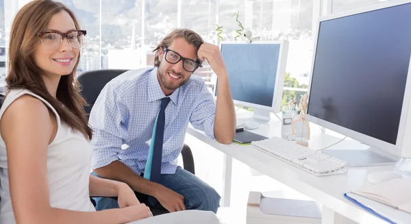 Designers sitting at their desk and smiling at camera — Stock Photo, Image