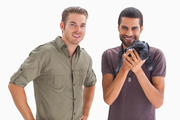 Elegantes amigos sonriendo con una cámara en la mano — Foto de Stock