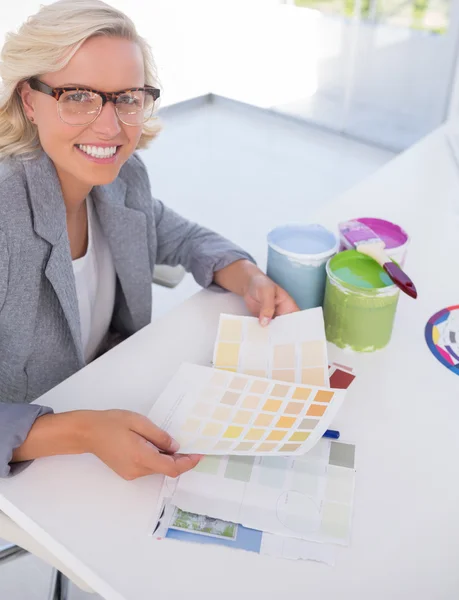 Cheerful blonde interior designer holding colour charts — Stock Photo, Image