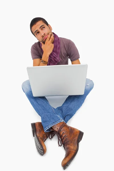 Thinking man sitting on floor using laptop — Stock Photo, Image