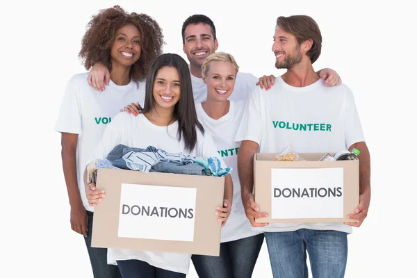 Feliz grupo de voluntarios sosteniendo cajas de donación de ropa — Foto de Stock