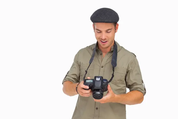 Homem feliz em cap pico segurando câmera — Fotografia de Stock