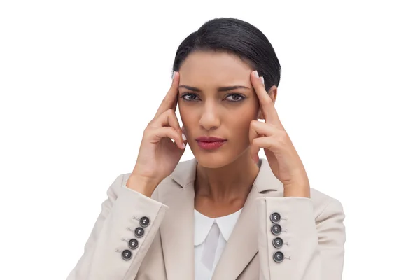 Young businesswoman putting her fingers on her temples — Stock Photo, Image
