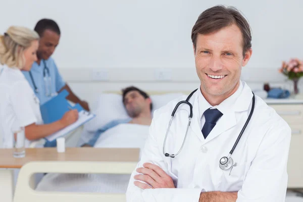 Médico sorrindo de pé e olhando para a câmera — Fotografia de Stock