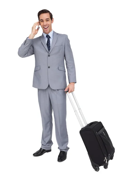 Smiling businessman with his luggage while phoning — Stock Photo, Image