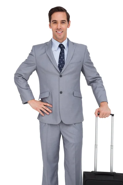 Smiling young businessman waiting with his luggage — Stock Photo, Image