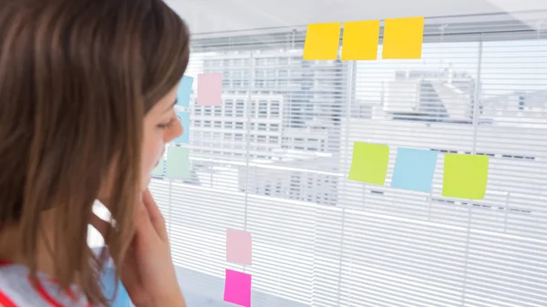 Woman looking at sticky note — Stock Photo, Image