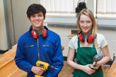 Two students holding a driller and a hammer clipart