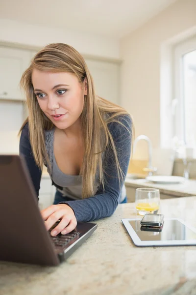 Frau tippt mit Smartphone und Tablet am Laptop — Stockfoto