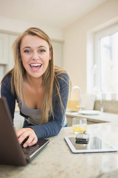 Skrattar kvinna på laptop med smartphone och tablet — Stockfoto