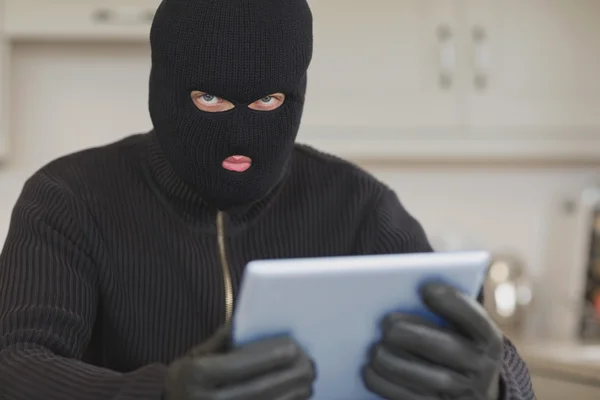 Burglar stealing the tablet pc — Stock Photo, Image