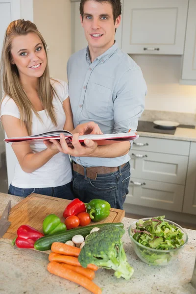 Счастливая пара с кулинарной книгой — стоковое фото