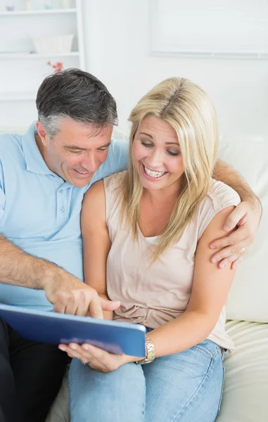 Couple assis sur le canapé regardant la tablette — Photo