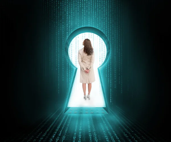 Businesswoman standing in keyhole doorway in blue and black matrix — Stock Photo, Image