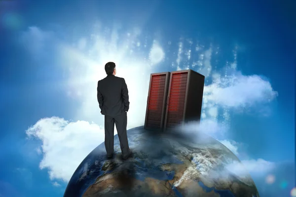 Businessman looking at servers on top of world — Stock Photo, Image
