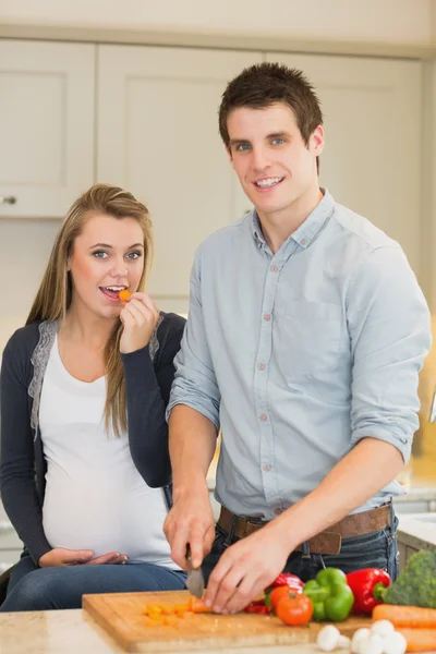 Mujer embarazada comiendo verduras preparadas por el marido —  Fotos de Stock