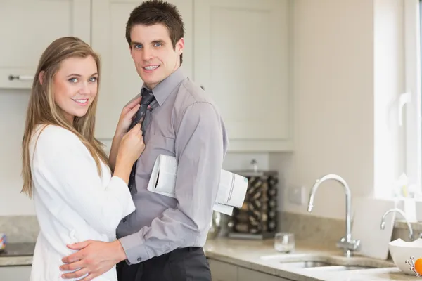 Man with a newspaper under his arm hugging his wife — Stock Photo, Image