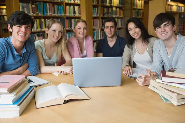 Six étudiants apprenant dans une bibliothèque avec un ordinateur portable — Photo