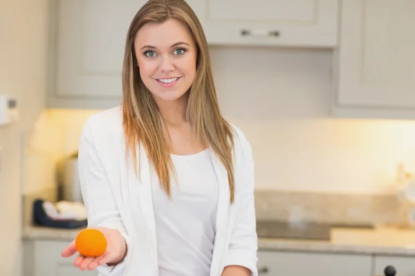 Vrouw met oranje in haar hand — Stockfoto