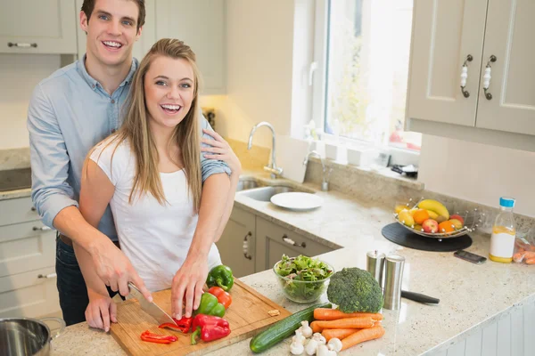 Paar lächelt und arbeitet in der Küche — Stockfoto