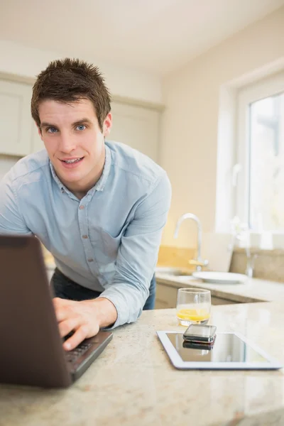 Man typing at the notebook with smartphone and tablet — Stock Photo, Image