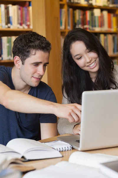 Dwóch studentów na laptopie w bibliotece — Zdjęcie stockowe