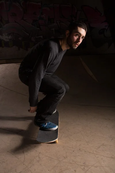 Patinador dobrando os joelhos para se preparar para um truque — Fotografia de Stock