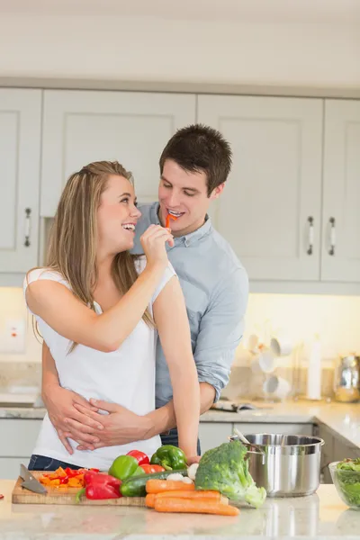 Woman feeding man with a pepper — Stock Photo, Image