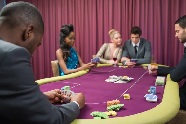 Homem olhando para suas cartas de poker — Fotografia de Stock