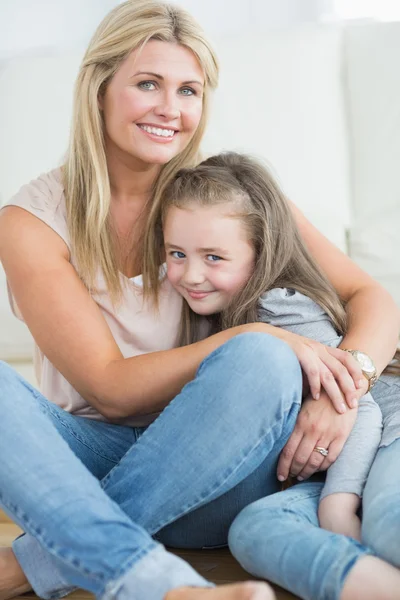 Matka a dcera objímat v obývacím pokoji — Stock fotografie