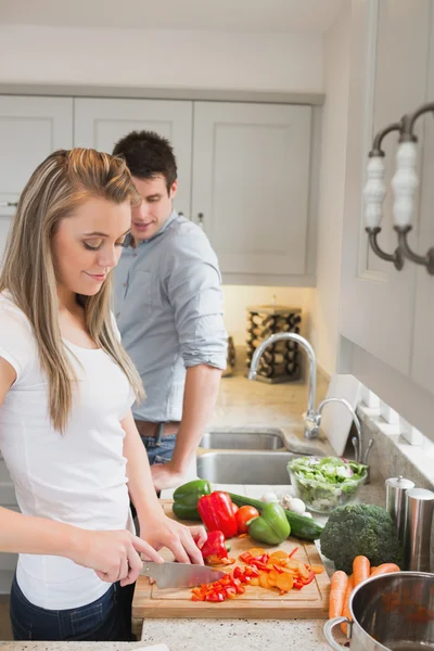Mulher gostando de cozinhar com homem assistindo — Fotografia de Stock