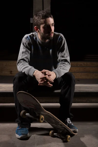 Скейтер, сидящий на ступеньках скейт-парка — стоковое фото