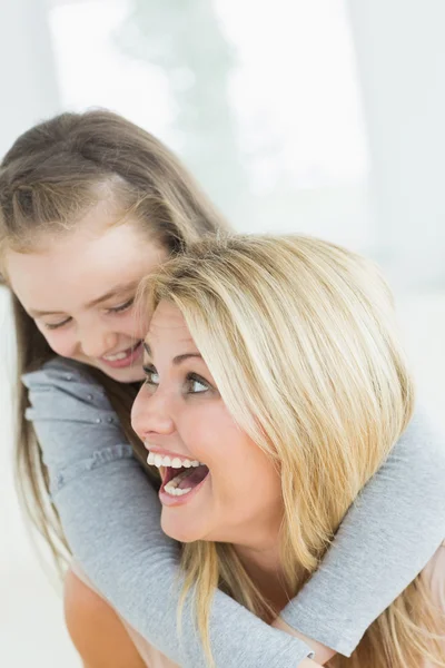 Rindo mãe dando filha um porquinho de volta — Fotografia de Stock