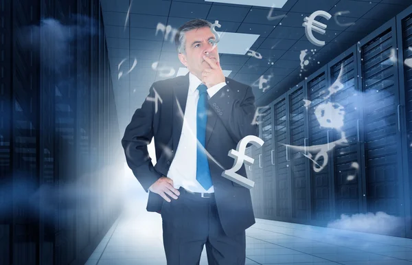 Businessman standing in data center with currency graphics — Stock Photo, Image