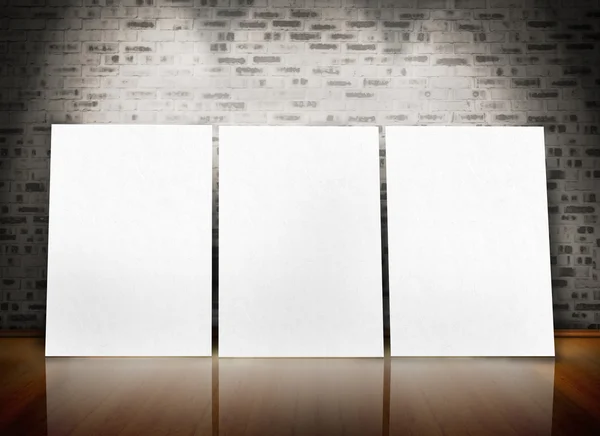 Three posters standing in line in a parquet floor like an art exhibition — Stock Photo, Image